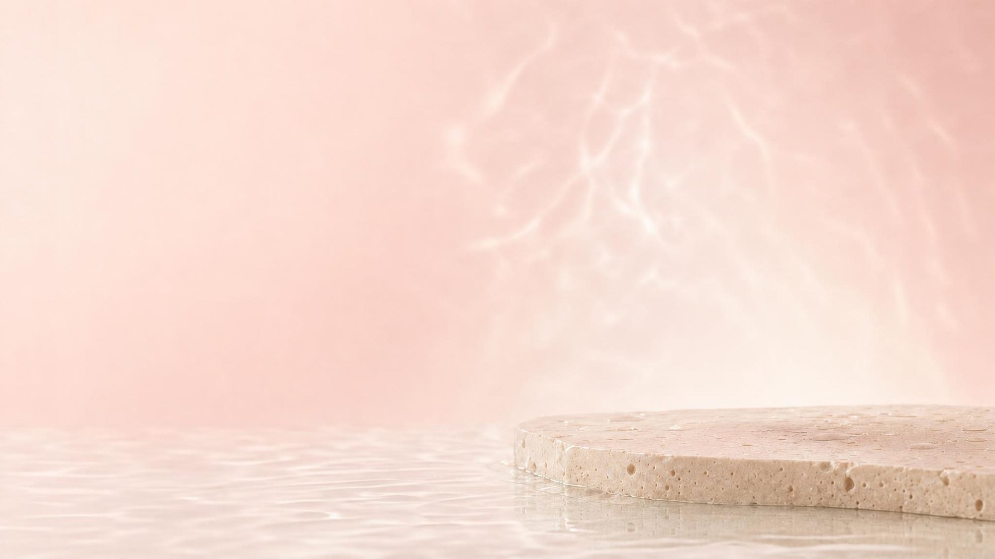 Pink Lumi Skin sonic facial brush on wet stone